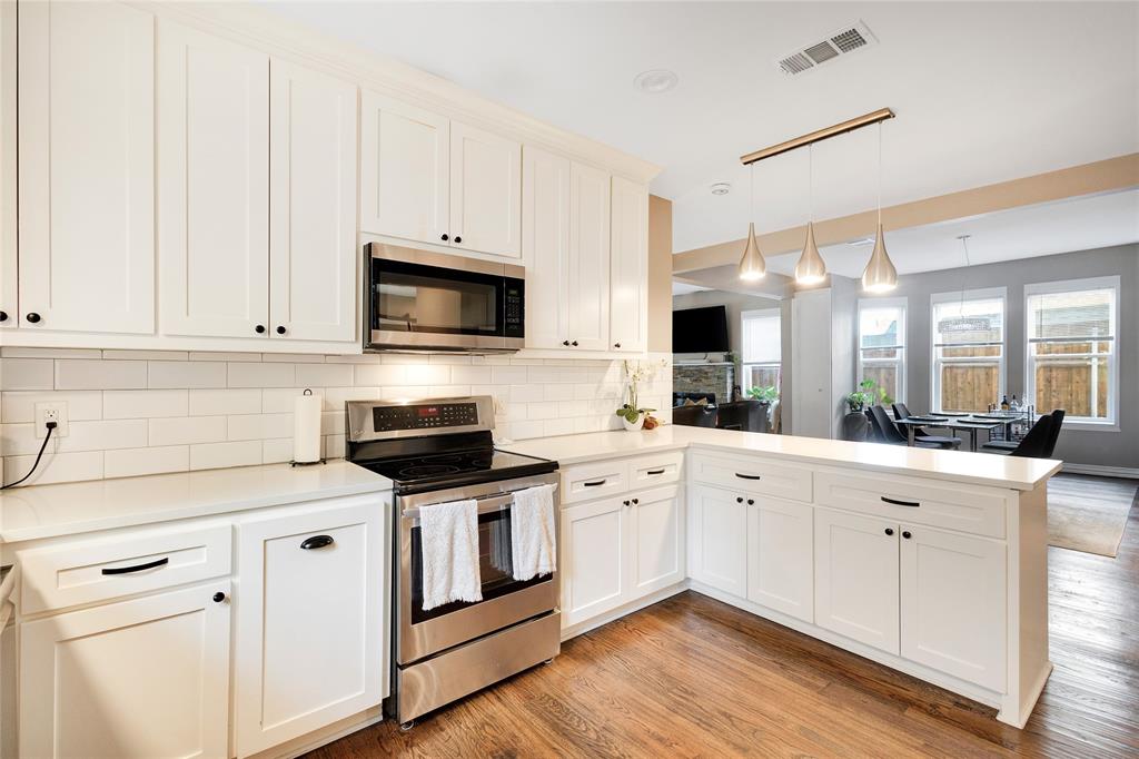 828 Elsbeth Street Dallas, TX 75208 - Photo 16 of 35 a kitchen with stainless steel appliances granite countertop a stove a sink and white cabinets