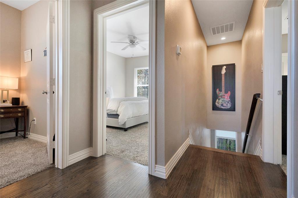828 Elsbeth Street Dallas, TX 75208 - Photo 18 of 35 a view of a hallway with a bedroom and wooden floor