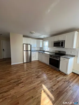 a kitchen with granite countertop a refrigerator stove top oven and sink