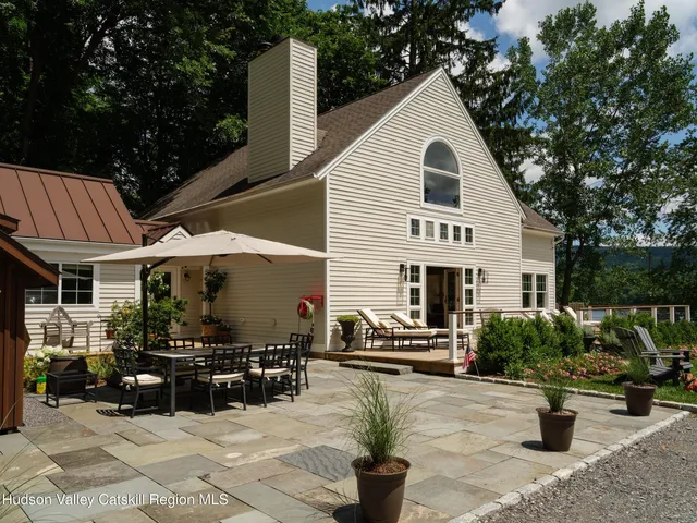 a view of a white house with a yard and sitting area