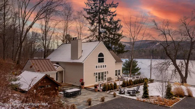 a view of a white house with large trees and outdoor space