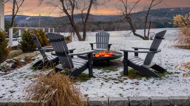 a view of a white house with a yard and sitting area