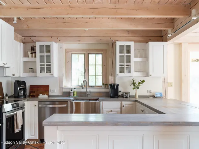 a kitchen with granite countertop a sink a counter top space cabinets and stainless steel appliances