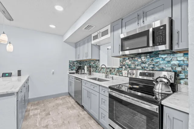 a kitchen with stainless steel appliances granite countertop a sink stove and cabinets