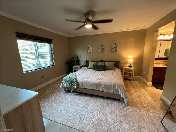 a spacious bedroom with a bed and a chandelier