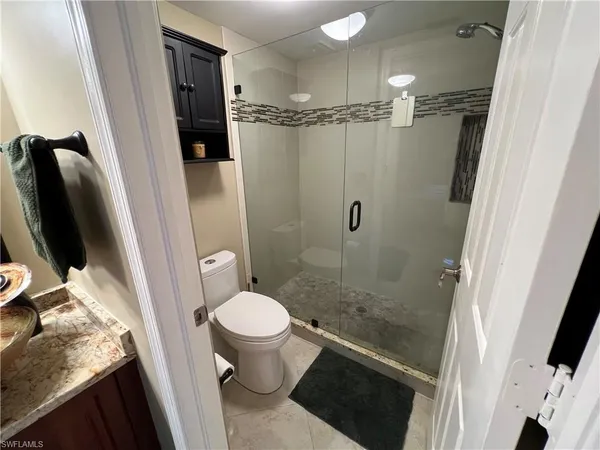 a bathroom with a granite countertop sink toilet and shower