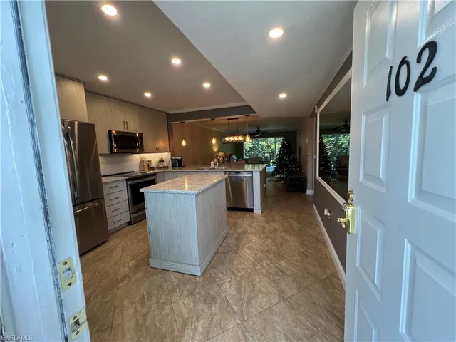 a large kitchen with a large counter top appliances and cabinets