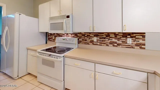 a kitchen with granite countertop white cabinets and white appliances