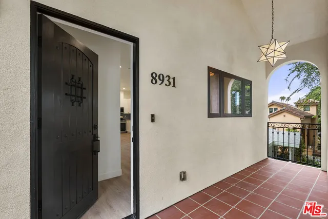 a view of a hallway with wooden floor and a front door