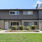 a front view of a house with a yard and potted plants