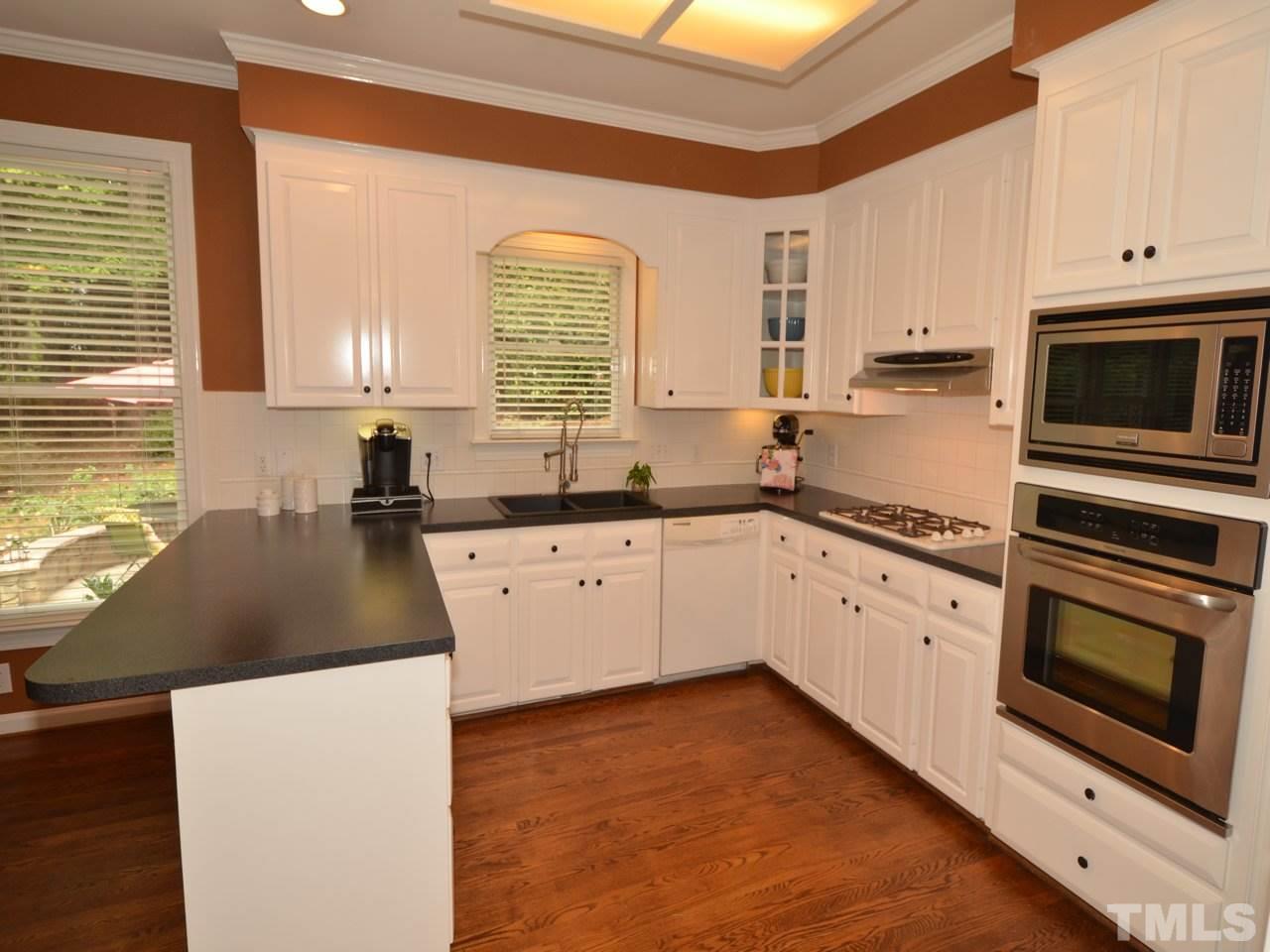 716 Presnell Court Raleigh, NC 27615 - Photo 3 of 25 a kitchen with stainless steel appliances granite countertop a stove a sink and a microwave