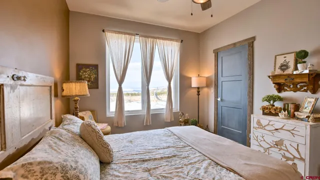 a bedroom with a bed and a dresser next to a window
