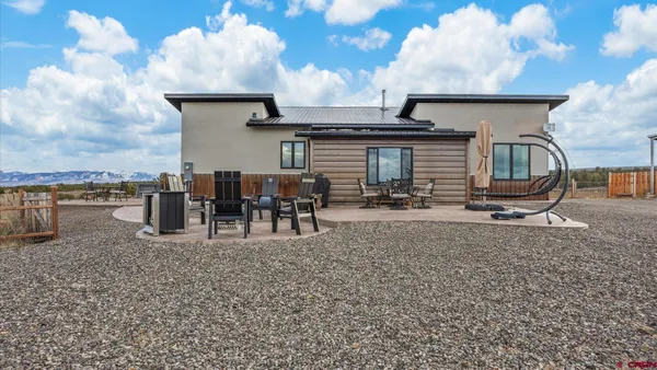 a backyard of a house with table and chairs