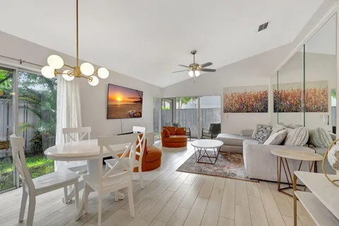 a living room with furniture a chandelier and a flat screen tv