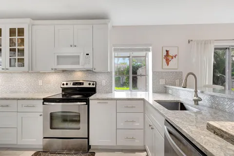 a kitchen with granite countertop a stove sink and cabinets