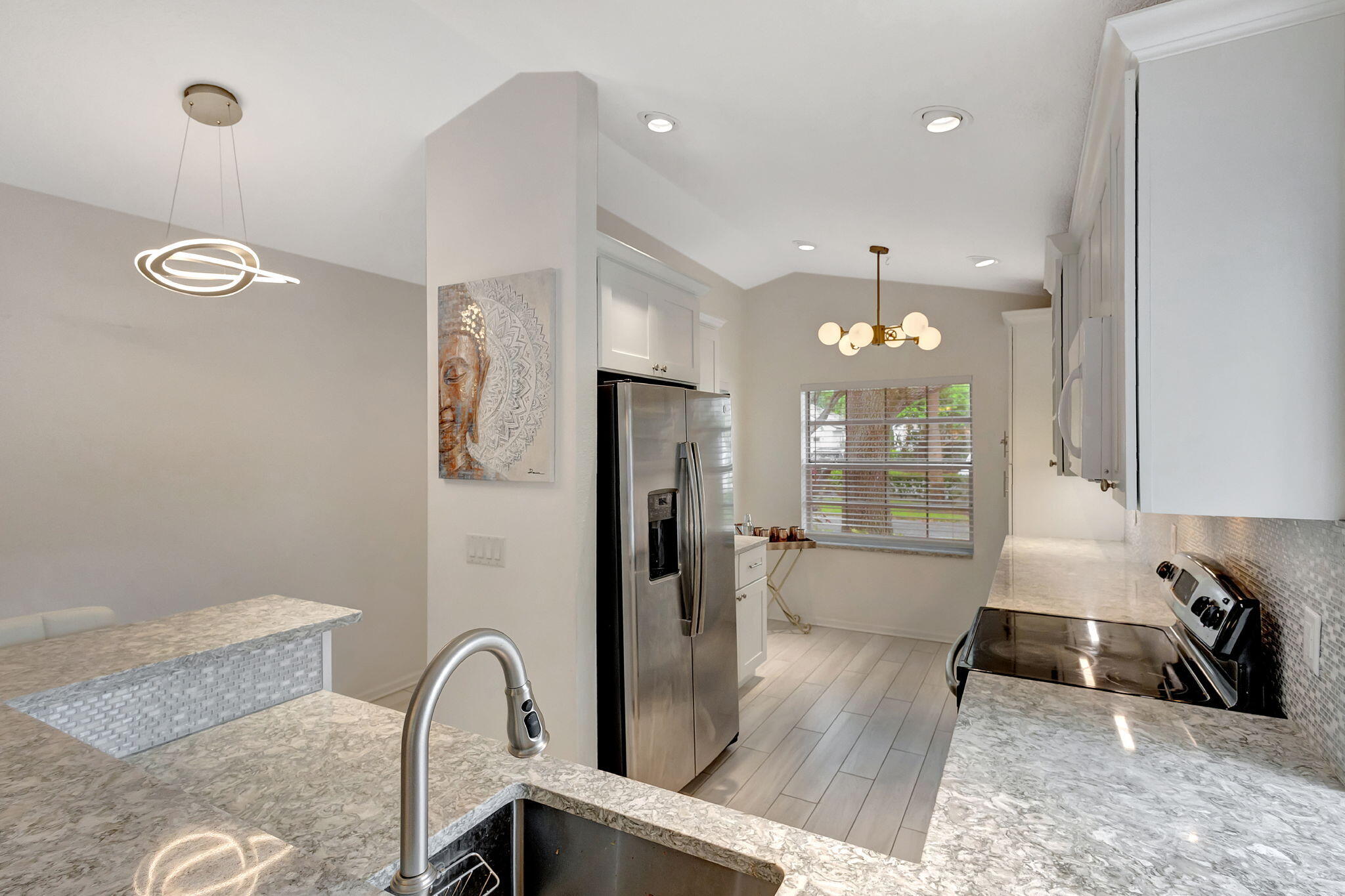 15 Admirals Court Palm Beach Gardens, FL 33418 - Photo 9 of 29 a kitchen with stainless steel appliances granite countertop a refrigerator a sink a stove and a wooden floors