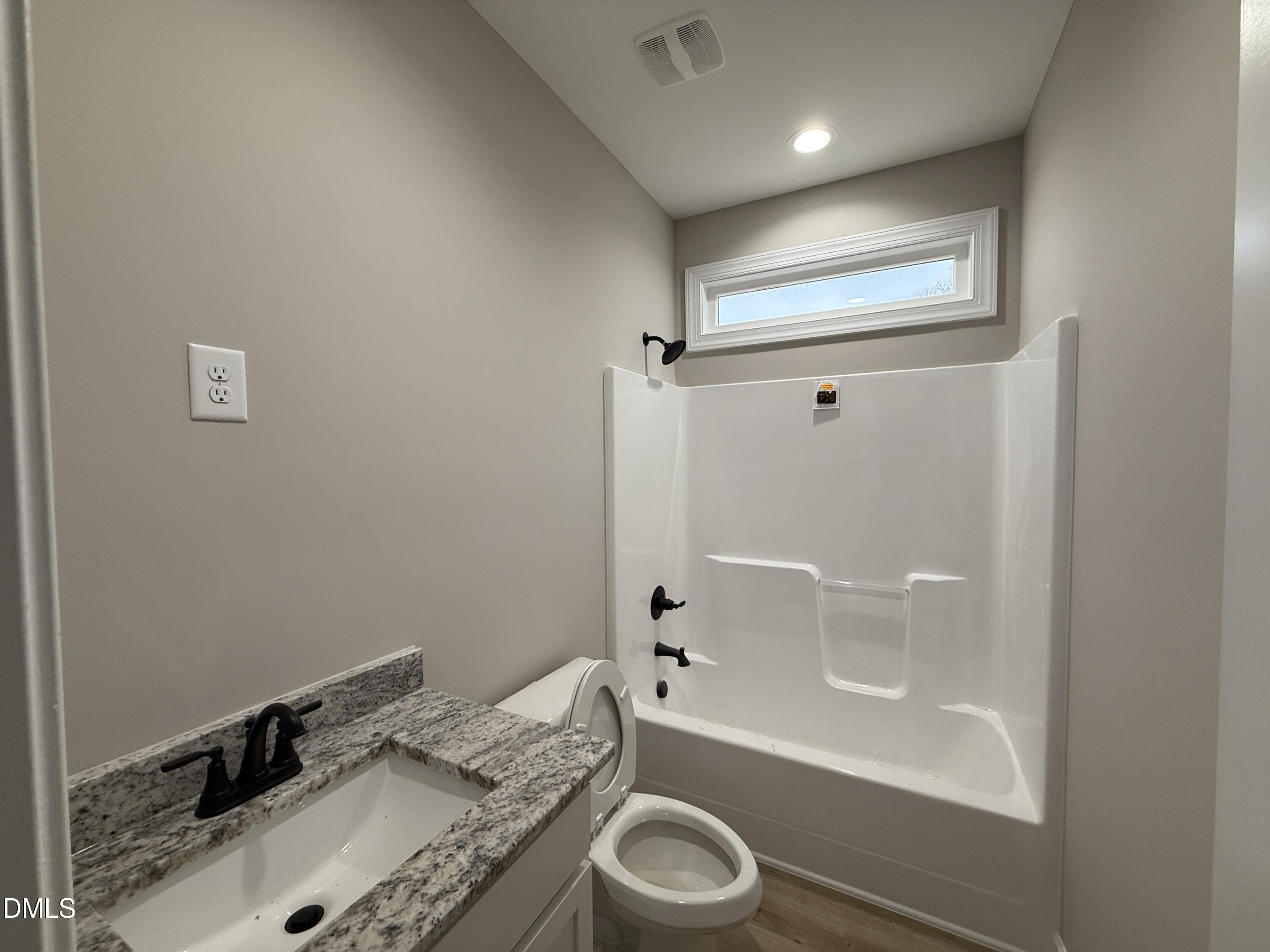 181 Royal Avenue Selma, NC 27576 - Photo 9 of 10 a bathroom with a granite countertop sink a toilet and bathtub