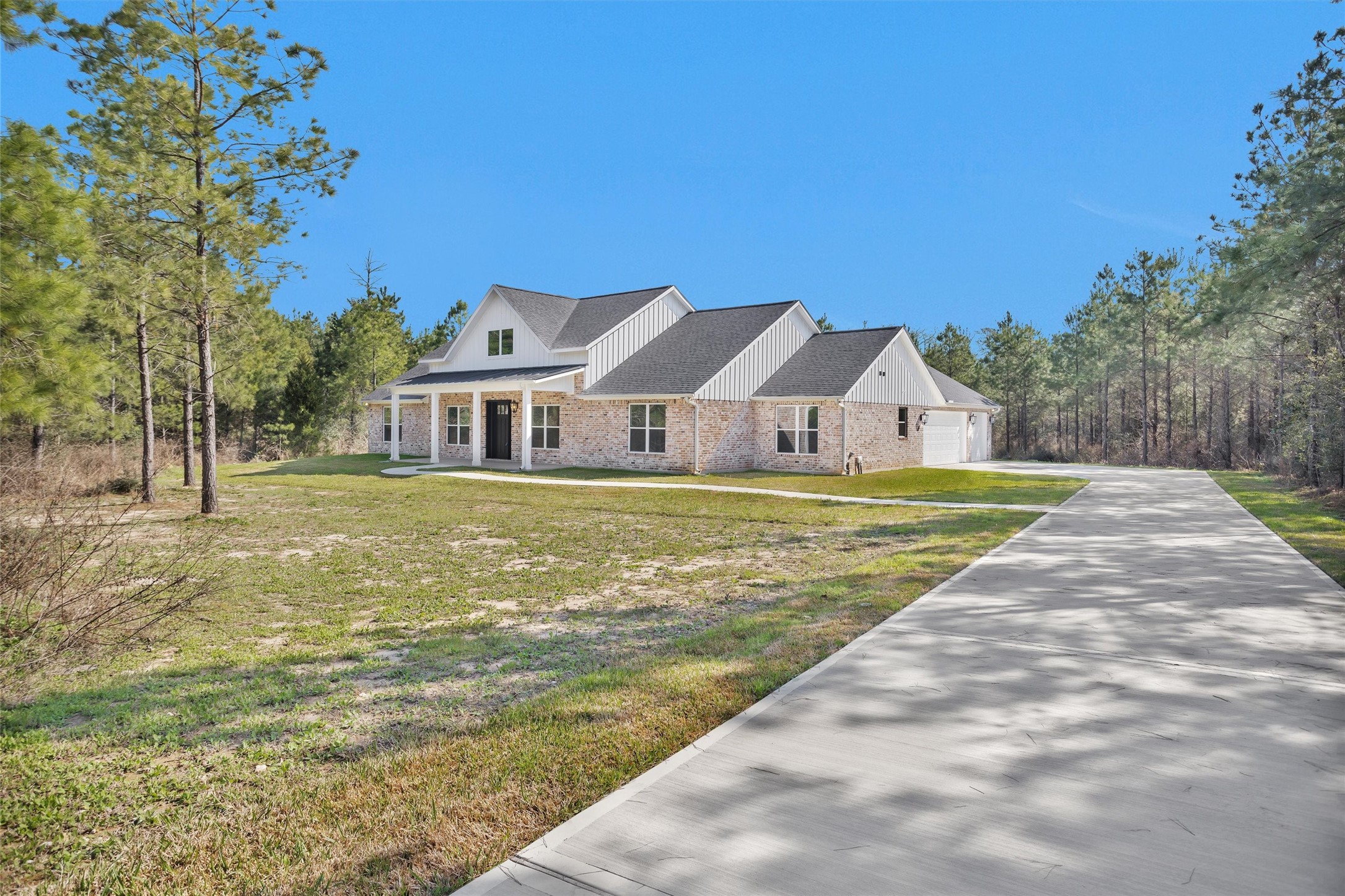 12744 Oak Barrel Road Willis, TX 77378 - Photo 2 of 50 Long private driveway leading to the home with a spacious three-car side-entry garage, offering ample parking and added curb appeal.