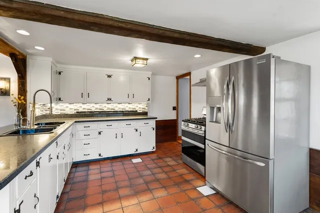 a kitchen with granite countertop a refrigerator and a sink