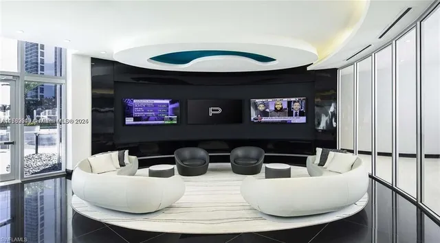 a living room with furniture a rug and a floor to ceiling window