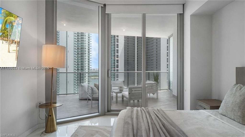 851 Northeast 1st Avenue, Unit 3303 Miami, FL 33132 - Photo 32 of 46 a bedroom with a bed and a mirror