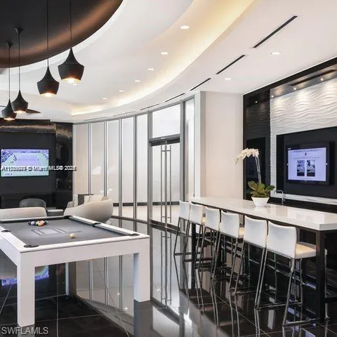 a room with furniture pool table and flat screen tv