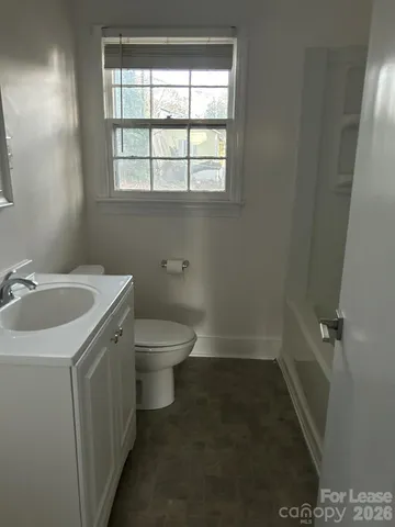 a bathroom with a sink toilet and window