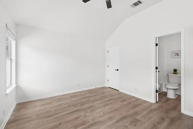 a view of room with a hardwood floor and a toilet
