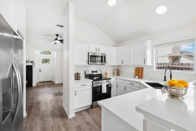 a kitchen with stainless steel appliances granite countertop a refrigerator sink and stove