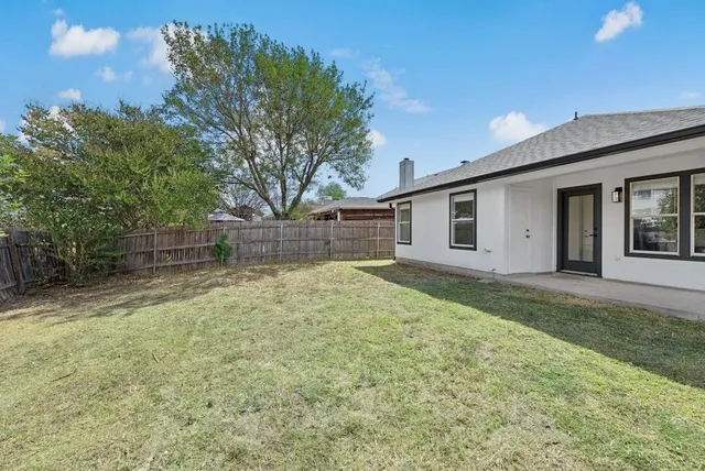 a view of a backyard with a garden and tree