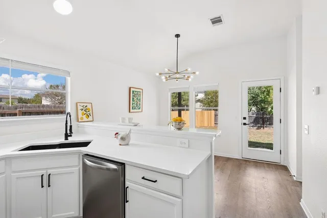 a kitchen with a sink cabinets and wooden floor