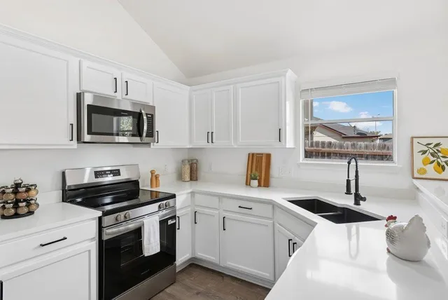 a kitchen with stainless steel appliances a sink stove and microwave