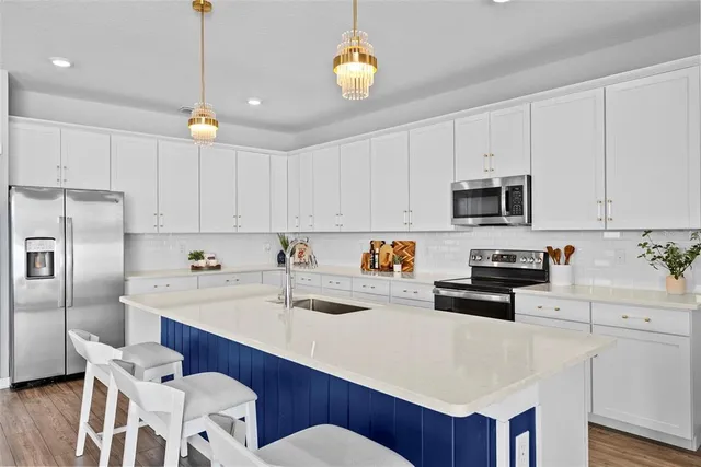 a kitchen with stainless steel appliances sink microwave and cabinets