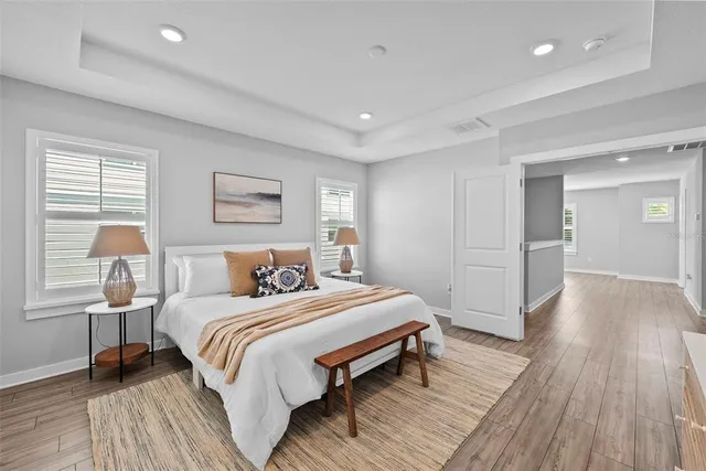 a bedroom with a bed and a lamp on dresser