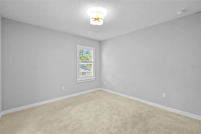 a view of a porch with chairs and floor to ceiling window