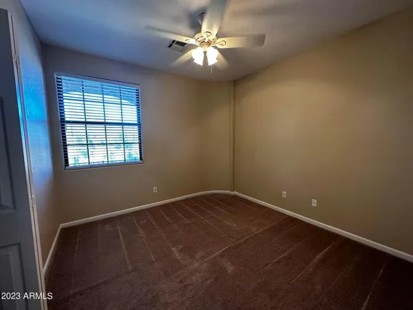 an empty room with windows and fan