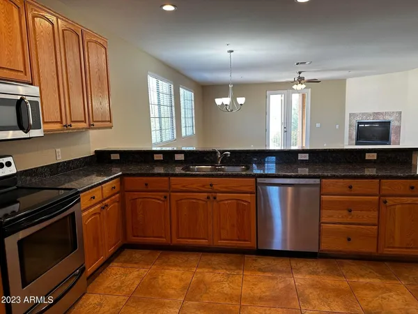 a kitchen with granite countertop a sink cabinets and stainless steel appliances