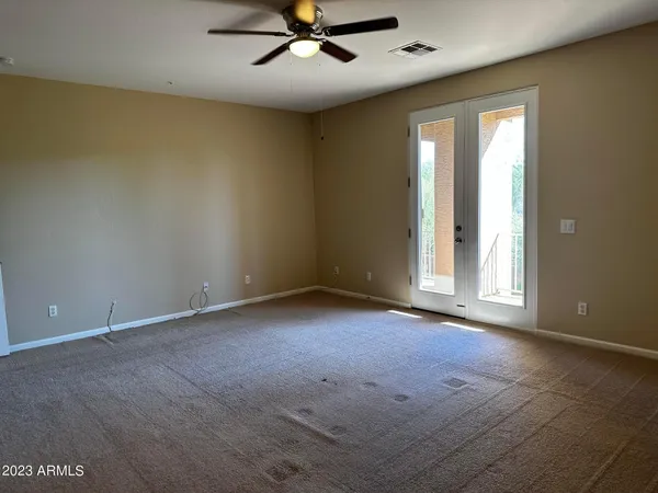 an empty room with a ceiling fan and window