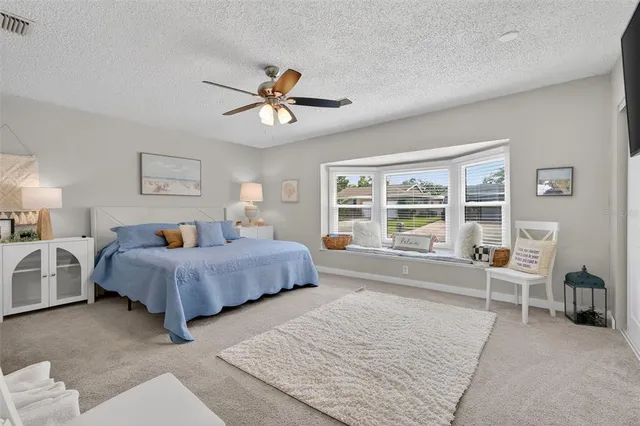 a spacious bedroom with a bed a couch and a view of en suite bathroom