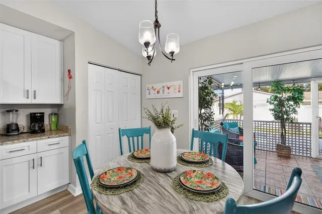 a view of a dining room with furniture a kitchen and chandelier