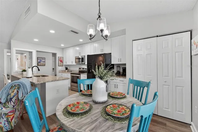 a view of a dining room with furniture a chandelier and wooden floor