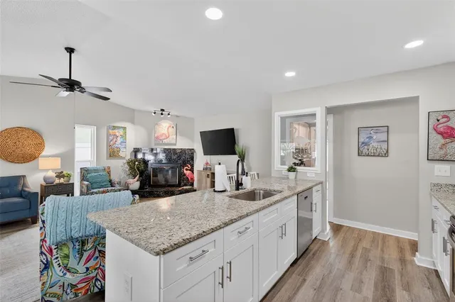 a kitchen with granite countertop a sink and a large mirror