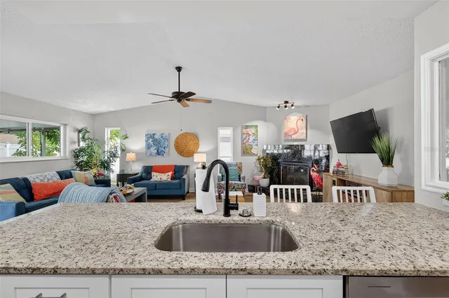 a kitchen with sink refrigerator dining table and chairs