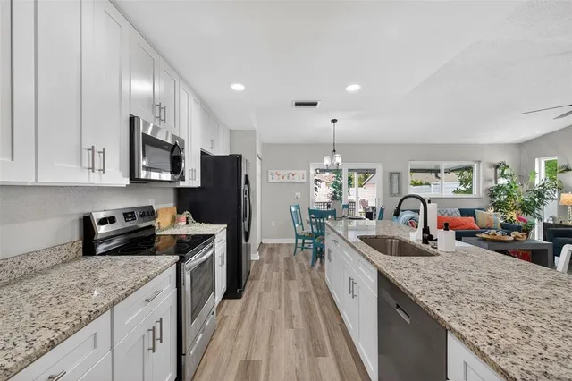 a kitchen with stainless steel appliances granite countertop a stove refrigerator sink and microwave