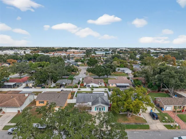 an aerial view of residential houses with outdoor space and trees