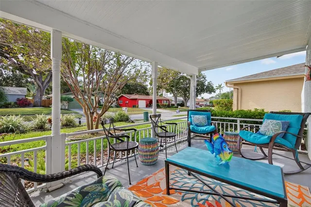 a living room with patio furniture and a floor to ceiling window