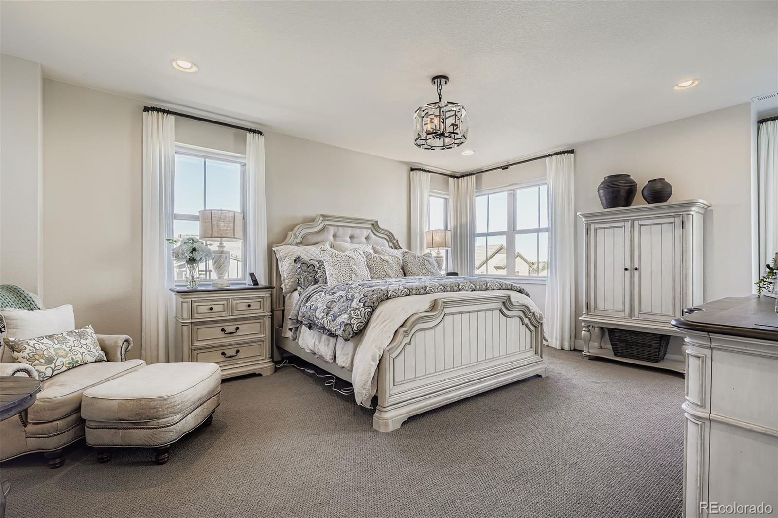 10414 Maplebrook Way Highlands Ranch, CO 80126 - Photo 16 of 45 a bedroom with a bed and a chandelier