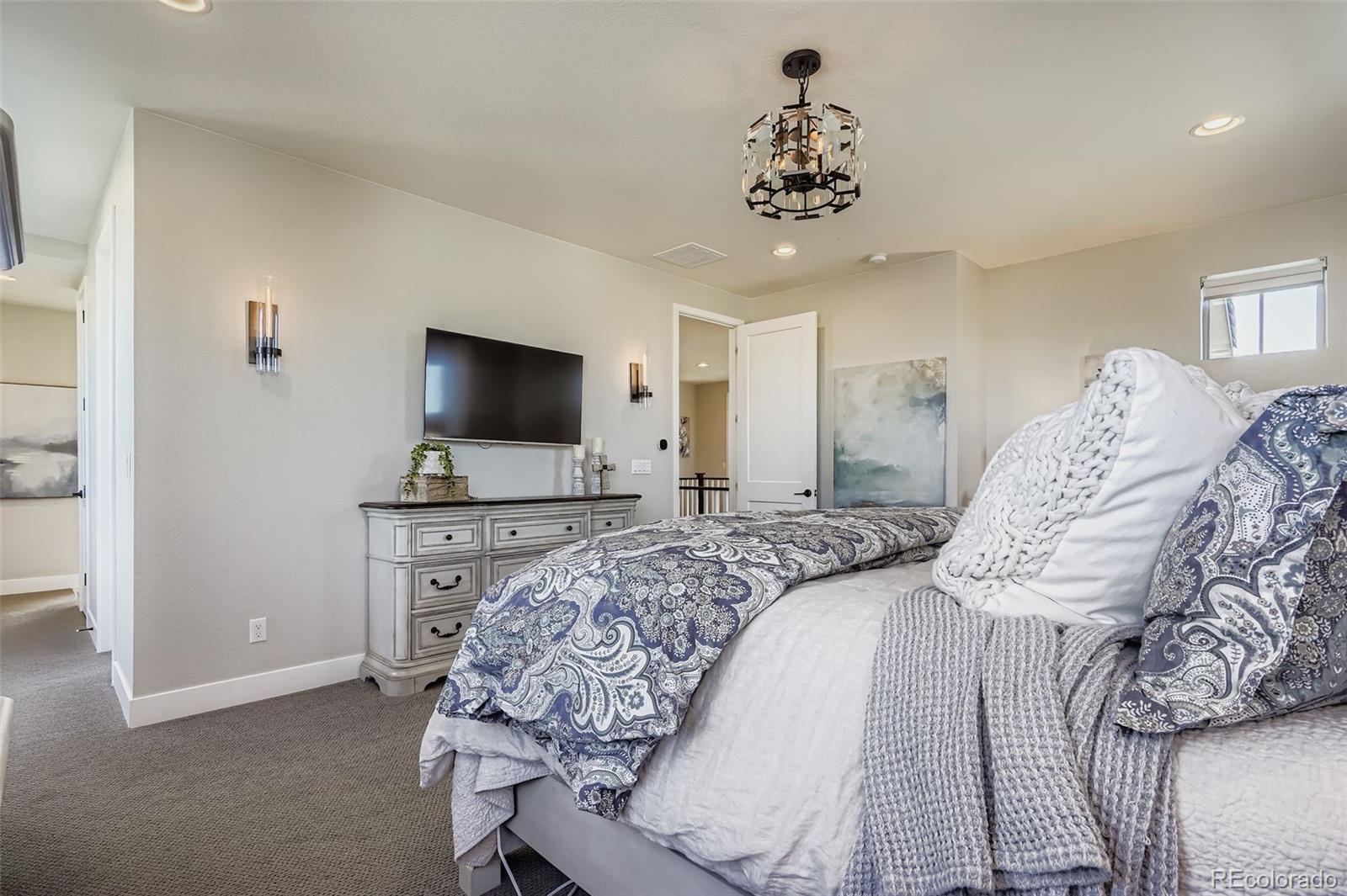 10414 Maplebrook Way Highlands Ranch, CO 80126 - Photo 18 of 45 a bedroom with a bed and a flat screen tv