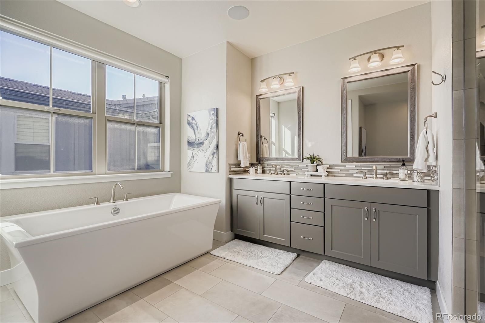 10414 Maplebrook Way Highlands Ranch, CO 80126 - Photo 19 of 45 a spacious bathroom with a double vanity sink a mirror and a bathtub