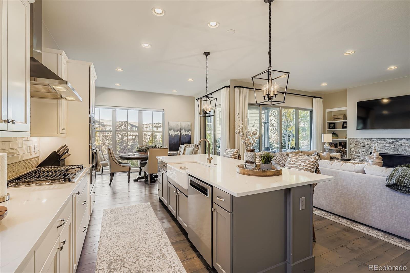 10414 Maplebrook Way Highlands Ranch, CO 80126 - Photo 2 of 45 a open kitchen with stainless steel appliances granite countertop a stove top oven a sink a dining table and chairs with wooden floor